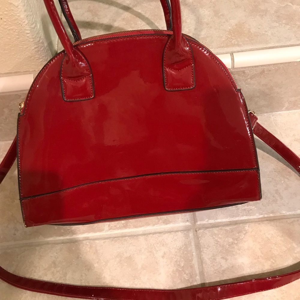 Deep red stiff standing patten leather purse.
